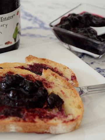 Toast with blueberry jam on a plate.