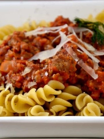 Dish or fusilli pasta with sausage and fennel sauce and fresh parmesan garnish