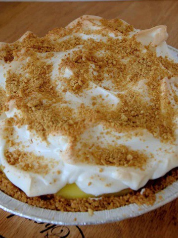 Whole pie with meringue topping and graham crumbs on top.