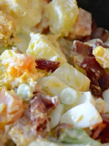 Potato salad with yellow and sweet potatoes, green onions and bacon bits in a creamy celery seed dressing.