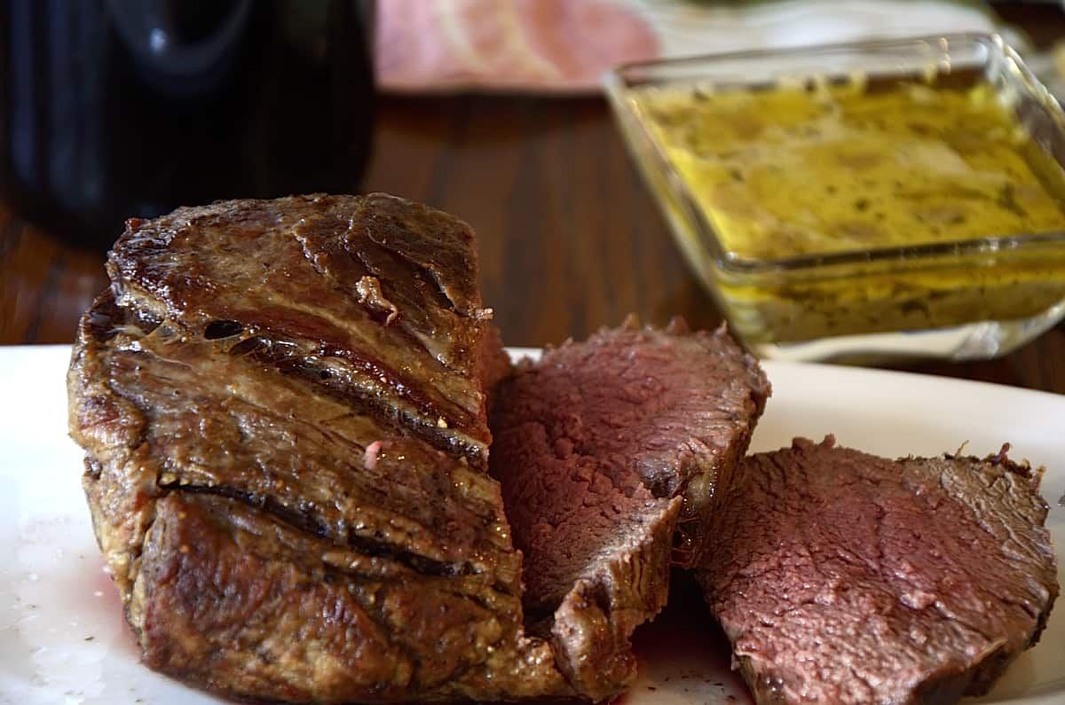 Medium rare beef tenderloin sliced on a platter.