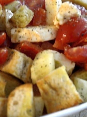 Rustic toasted croutons with chopped tomatoes for panzanella salad.