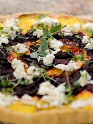 Butternut squash tart garnished with boursin cheese and microgreens.